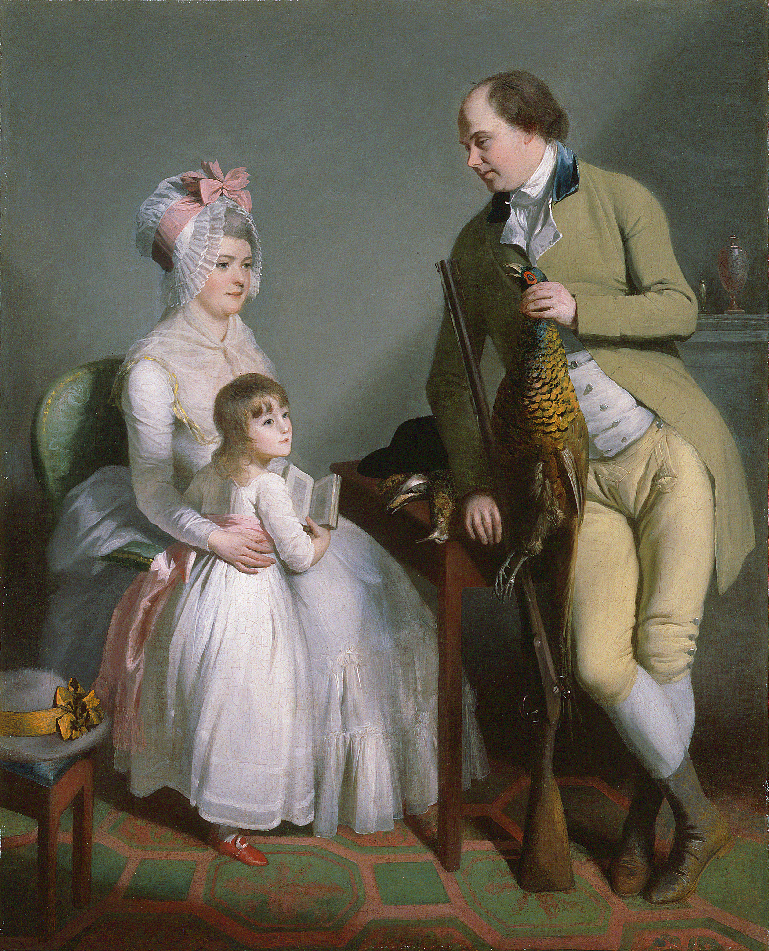 Oil painting showing a seated woman in a white dress with a child in a white dress leaning on her knees. A main in a green suit stands to their left, leaning on the arm of the chair. He is carrying a dead pheasant in one hand,